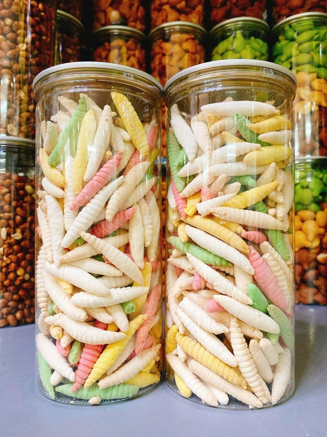 br/> Bánh đuông còn được gọi là bánh sâu, bánh sùng, do hình dáng bánh giống những con vật này. Đây là món ăn vặt tuổi thơ được nhiều người ưa thích, có độ giòn xốp đặc trưng, vị thơm béo. Ngoài màu trắng "cổ điển", người ta cũng cho màu thực phẩm để tạo ra bánh "ngũ sắc" đủ màu đẹp mắt. Ảnh: Duhofoods.