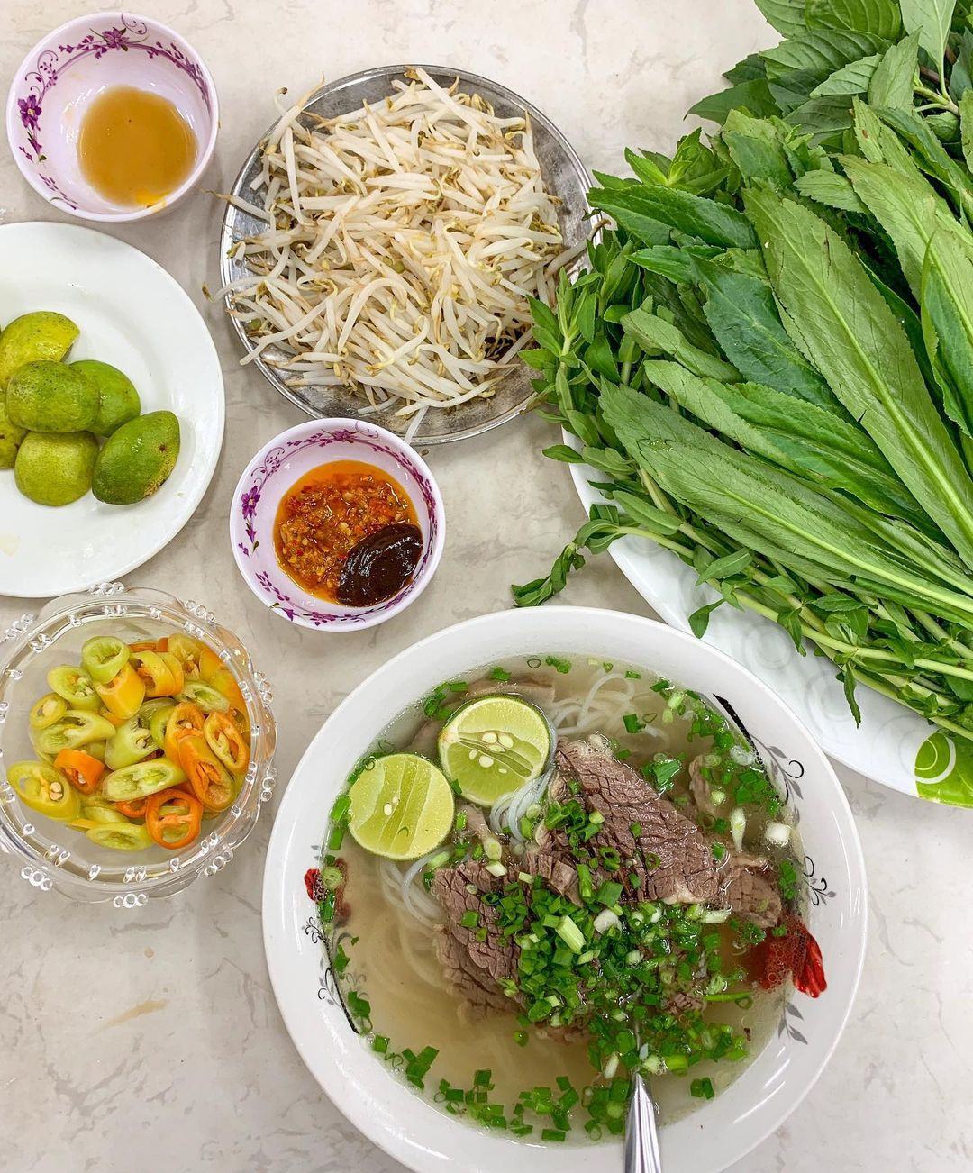 Ngò rí, ngò gai ở miền Nam được gọi mùi ta (rau mùi), mùi tàu ở miền Bắc. Đây đều là những loại gia vị khá quen thuộc trong ẩm thực Việt Nam. Lấy phở bò làm ví dụ. Tại TP.HCM, người ta thường phục vụ phở bò kèm theo đĩa giá sống hoặc giá trụng, chanh, ớt, ngò gai, húng quế... Ảnh: Agirlaboutchicago.