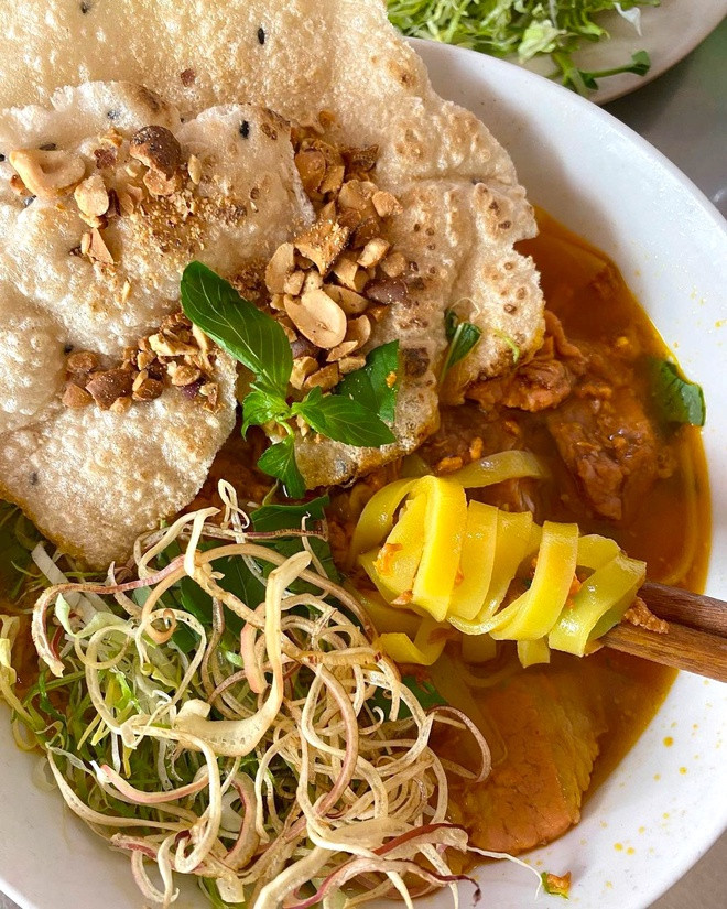 br/> Mì Quảng vốn là đặc sản trứ danh ở Quảng Nam, Đà Nẵng, kết hợp sợi mì dài dẹt với "nhưn" chế biến từ các loại thịt, trứng, hải sản nêm nếm đậm đà, thêm bánh tráng nướng, đậu phộng, các loại rau thơm... Tô mì Quảng "đúng điệu" ở miền Trung thường chỉ chan xăm xắp nước, trong khi đó, một số quán ăn tại Đà Lạt thường chan nhiều nước dùng hơn, ngập cả sợi mì. Ảnh: Carinarabanzo.