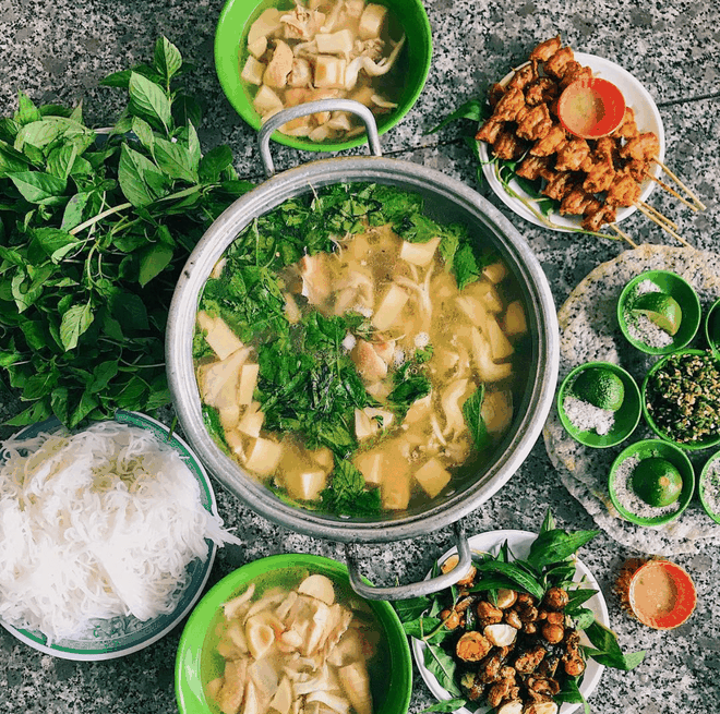 br/> Ở xứ sở nghìn hoa, nhiều quán bán món lẩu gà lá é. Khi thưởng thức, bạn sẽ cảm nhận nước dùng nóng hổi quyện vị dai, mềm thơm của thịt gà, ngọt từ nấm, hơi chua bởi măng và chút the mát nhờ lá é. Phần ăn thường đi kèm bún, đĩa lá é tươi, chén muối ớt hiểm cay nồng hoặc muối tiêu chanh để chấm thịt gà. Ảnh: Thon.foodie.