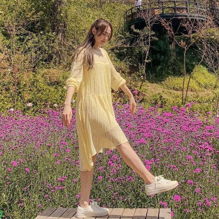 Minh Hằng vừa ngọt ngào dịu dàng nhưng lại không kém phần năng động, trẻ trung với chiếc đầm suông phủ tông màu vàng pasteel tươi sáng, phối cùng giày sneakers trắng sành điệu. Cách ăn diện này giúp cô trẻ trung ra vài tuổi.