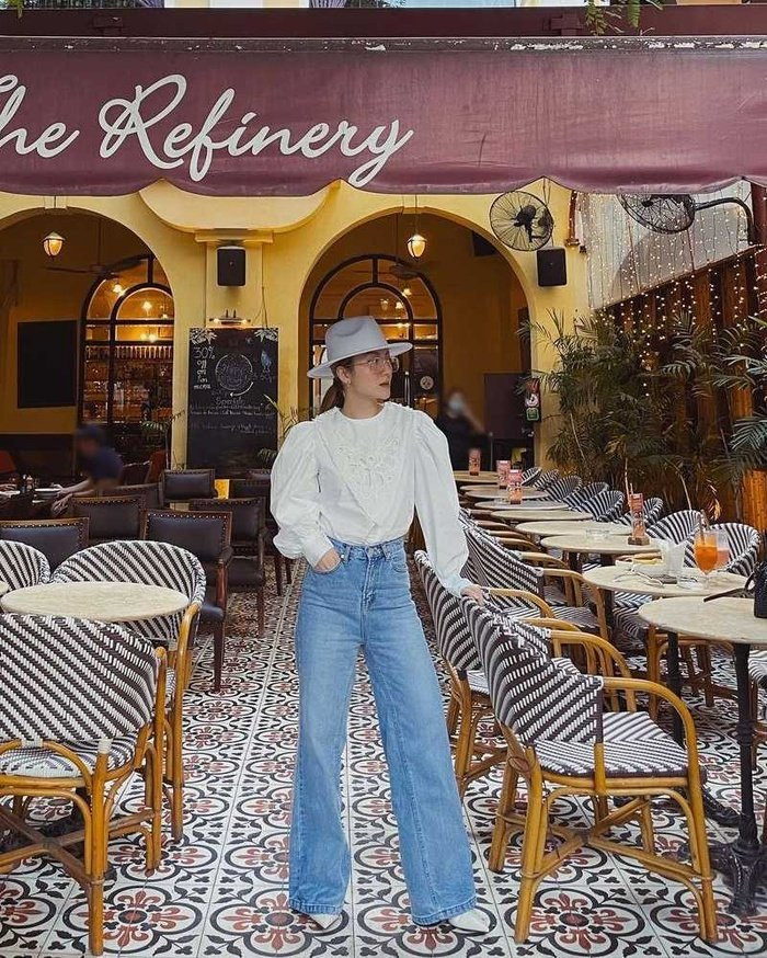 Yến Nhi chọn thiết kế quần jeans ống rộng, cạp cao, kết hợp cùng áo blouse trắng. Cô nàng còn khéo chọn giày và mũ fedora tiệp màu trắng tạo nên một tổng thể tinh tế.