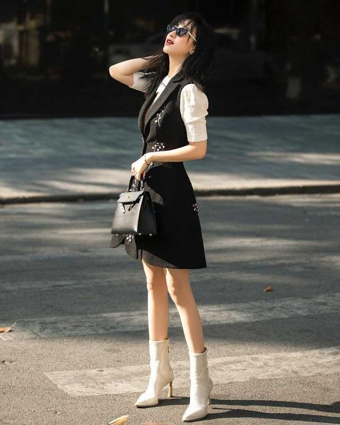 Hà Thu hết mực sang chảnh trong set đồ mang hai tông màu trắng đen cơ bản khi phối sơ mi trắng tay bồng cùng váy nhấn eo, lần lượt hoàn thiện bộ cánh bằng boots cao gót và túi xách đắt tiền.