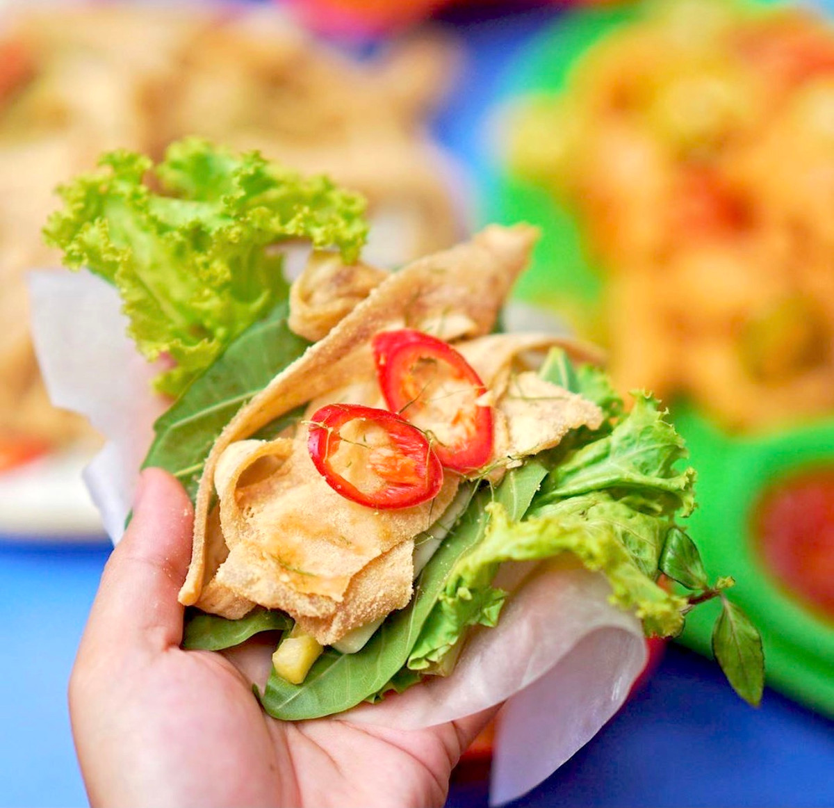 Nem tai là món ăn dân dã nổi tiếng ở Hà Nội. Thực khách có thể dùng bánh tráng cuộn miếng nem tai, rau sống, lá sung rồi chấm nước mắm đậm đà. Khi ăn, bạn sẽ dễ dàng cảm nhận vị giòn từ nem tai, thanh mát của rau. Ảnh: Mysteriousaigon.