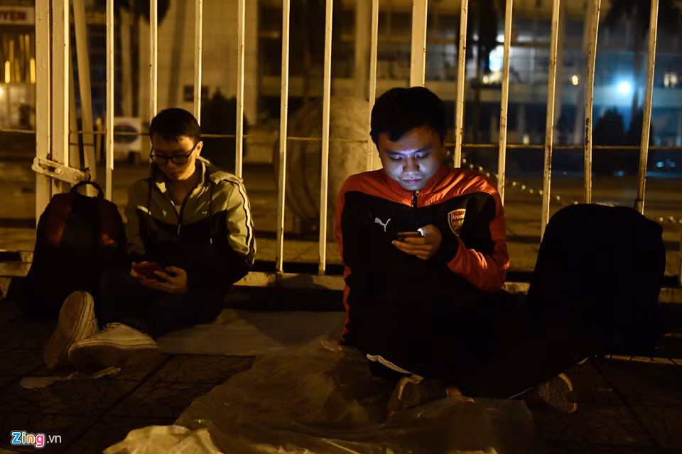 Phạm Công Minh (áo khoác đỏ) từ Yên Bái lên thủ đô từ tối. Minh cho biết yêu bóng đá thực sự và quyết tâm săn vé để vào sân cổ vũ đội nhà. "Mấy năm trước em còn dựng lều cùng người yêu tại đây chờ mua vé. Năm nay bạn gái đã thành vợ và ở nhà trông con nên em đi cùng bạn", Minh nói.