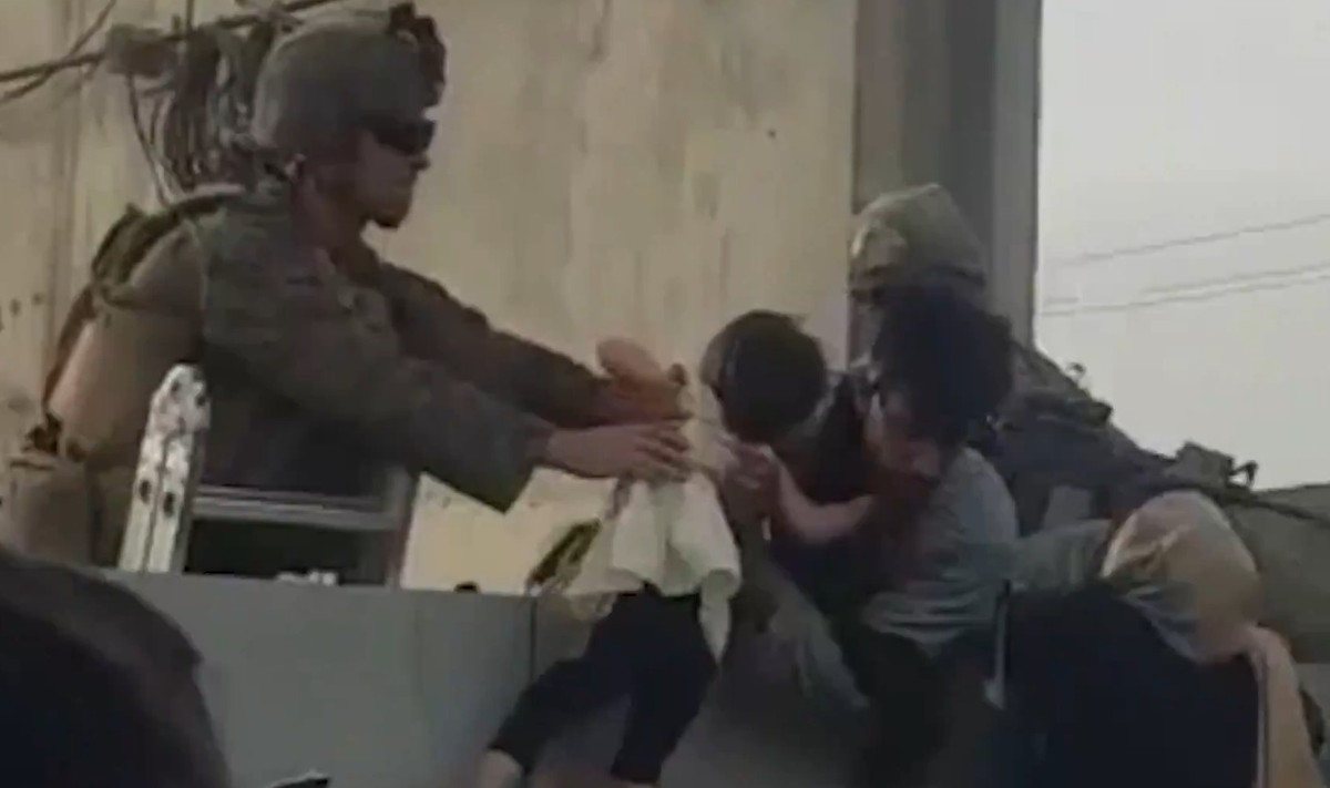 Báo Telegraph miêu tả không khí hoảng loạn và tuyệt vọng giữa những người tập trung ở bờ tường bao quanh sân bay. Một đứa trẻ được chuyền tay từ người này qua người khác ở trên không, bởi đám đông đã kẹt cứng không thể di chuyển. Ảnh: New York Post.