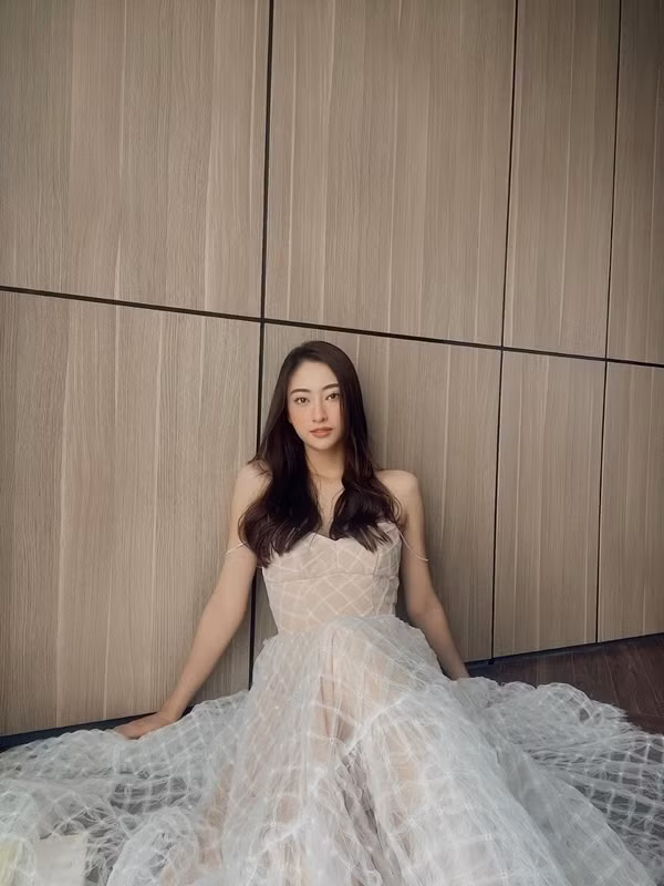 Thay vì những bức hình lộng lẫy trên thảm đỏ, hoa hậu Lương Thùy Linh đã chọn chính căn phòng ngủ làm “studio” cho những bức hình thời trang. Người đẹp diện đầm voan trắng cúp ngực với phần quai cách điệu bằng chuỗi hạt mỏng manh, tôn lên nét quyến rũ mơ màng. Lương Thùy Linh nền nã trong mái tóc buông xõa tự nhiên, tone trang điểm nhẹ nhàng.