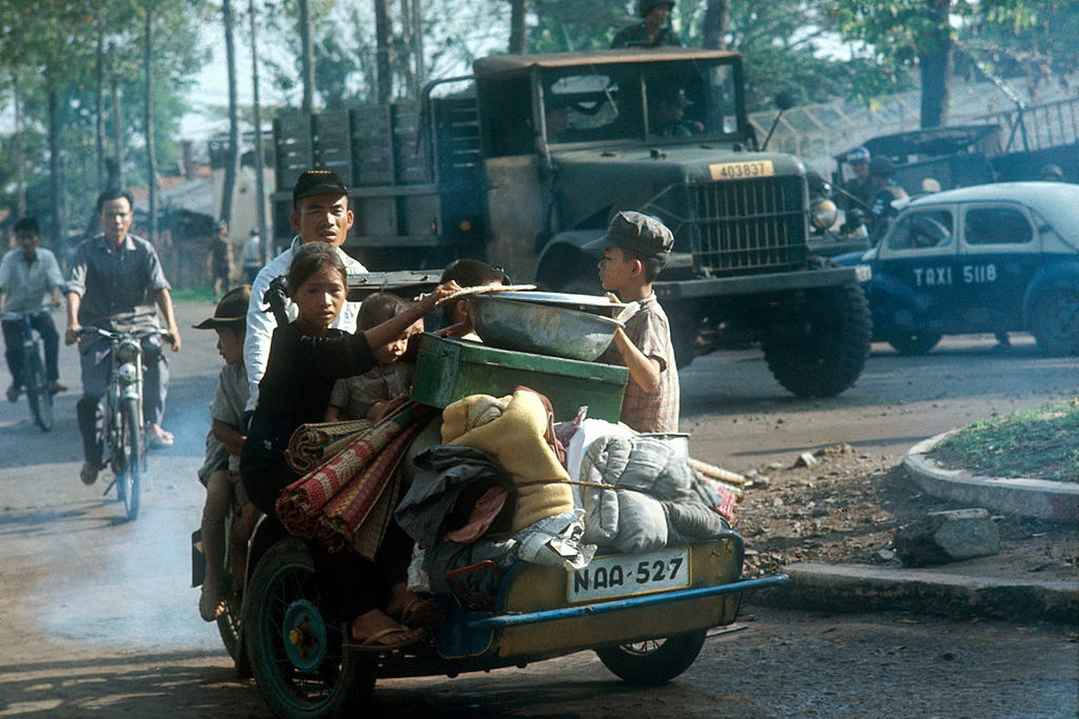 Một gia đình di tản bằng xích lô máy tại ngã tư Trần Quốc Toản – Nguyễn Văn Thoại (nay là ngã tư 3 Tháng 2 – Lý Thường Kiệt) trong chiến sự Mậu Thân 1968. Ảnh: Angelo Cozzi.