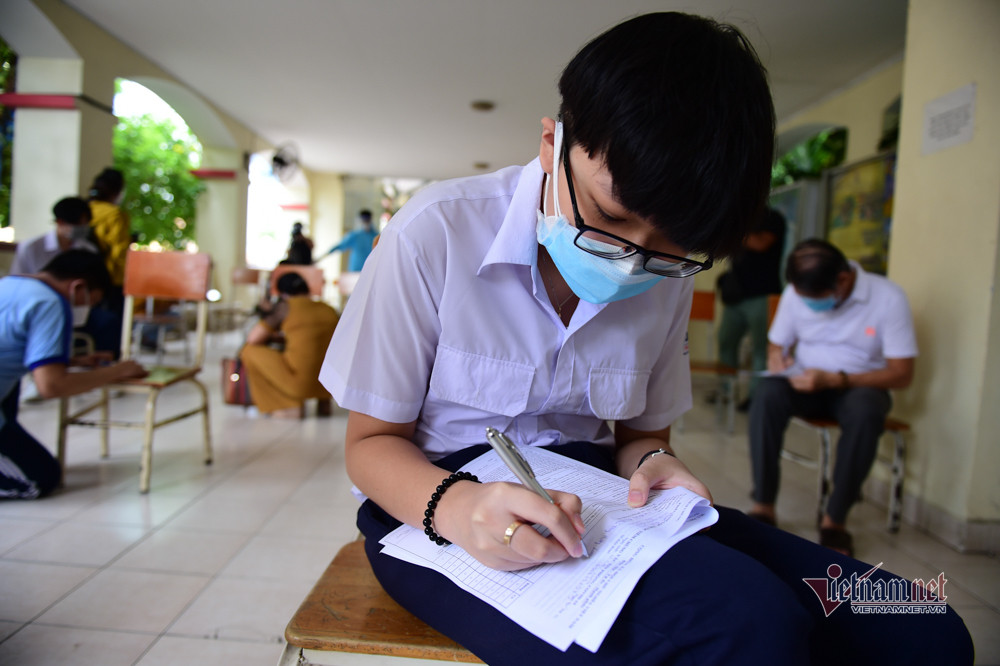 Em Phạm Phú Lộc ghi thông tin trước khi tiêm. Em cho biết: "Mọi người ai cũng tiêm nên em không thấy lo lắng gì".