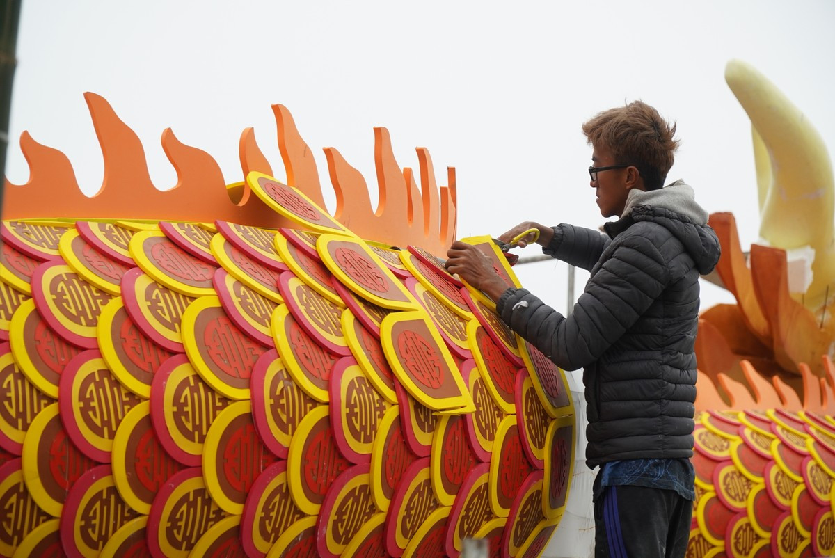 Phía ngoàimình rồngđược làm bằng xốp dẻo.Vảy rồngcó hình chữ "Thọ" cách điệu với các màu đỏ, vàng, huyết dụ.