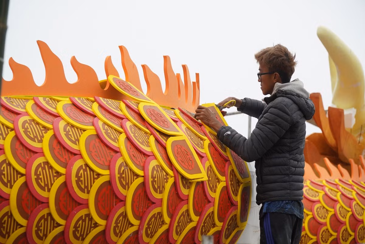 Phía ngoàimình rồngđược làm bằng xốp dẻo.Vảy rồngcó hình chữ "Thọ" cách điệu với các màu đỏ, vàng, huyết dụ.