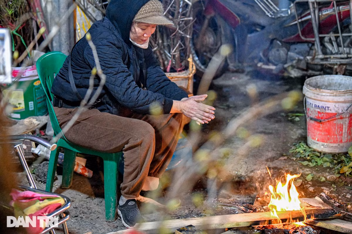 Thời tiết Hà Nội về đêm có lúc xuống dưới 10 độ C, các tiểu thương bán hoa phải đốt củi sưởi ấm. 