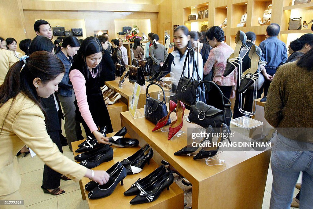 Khách hàng xem giày dép và túi xách được bán tại một cửa hàng bên trong trung tâm mua sắm mới mở ở trung tâm thành phố Hà Nội, 23/11/2004.