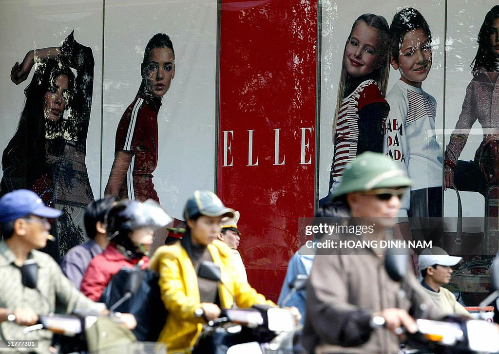 Người đi xe máy đi ngang qua bảng quảng cáo cho một thương hiệu nước ngoài tại trung tâm Hà Nội, ngày 23/11/2004. Ảnh: Hoang Dinh Nam / Getty Images.