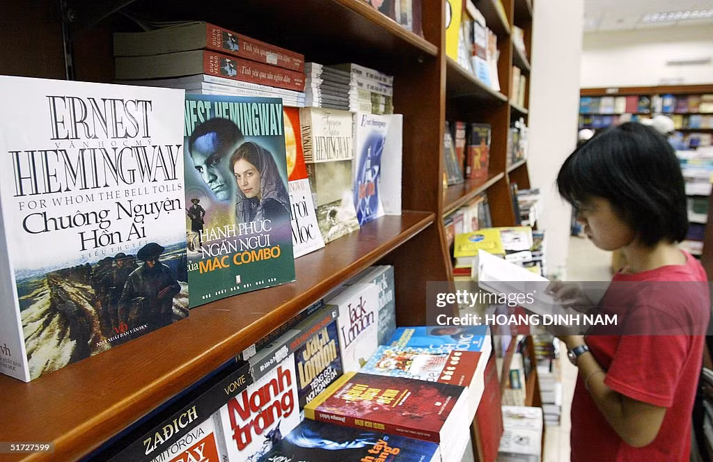 Một phụ nữ trẻ đọc sách tại quầy văn học nước ngoài bên trong một hiệu sách ở trung tâm Hà Nội, 11/11/2004.