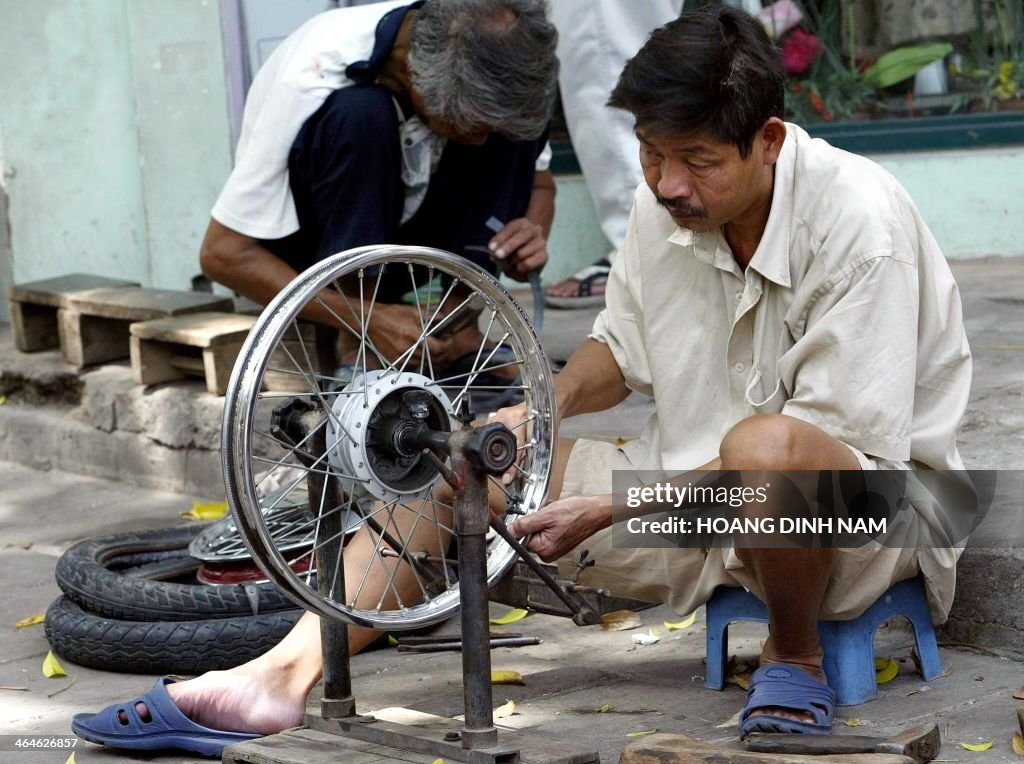 Người sửa xe hành nghề trên vỉa hè, 26/8/2004.