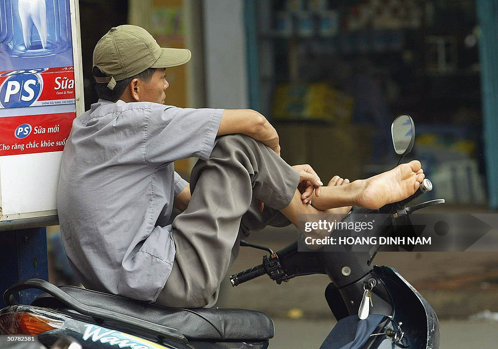 Người lái xe ôm chờ khách ở một góc phố, 29/4/2004.