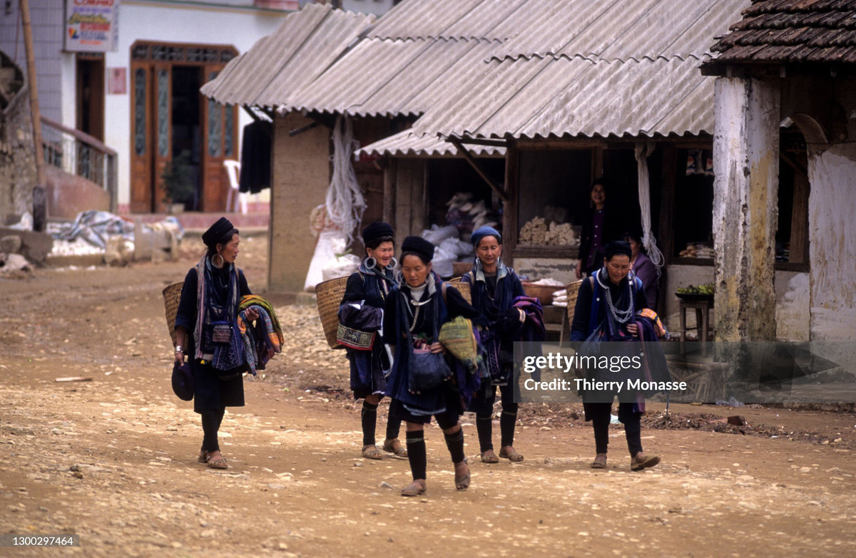 Nhóm phụ nữ người H'Mông bước đi trên con đường ở trung tâm thị trấn.