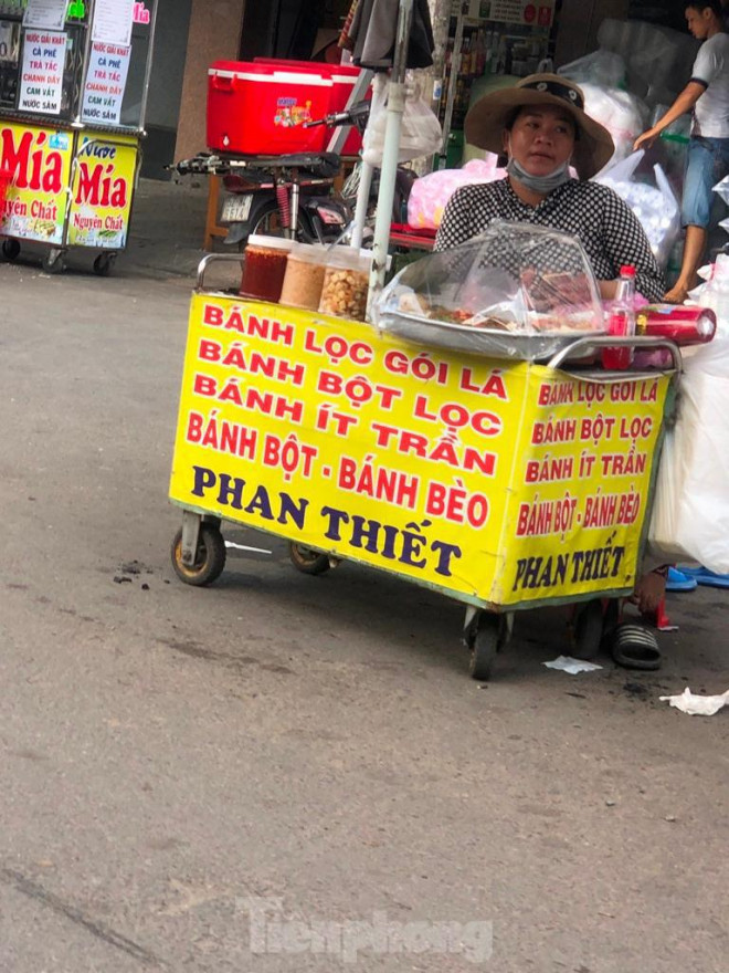 Người bán hàng mang khẩu trang chỉ để... cho có. Một số người kinh doanh cho hay, trời nắng nóng nên tranh thủ lúc không có khách, kéo khẩu trang xuống chút cho dễ thở (?!).