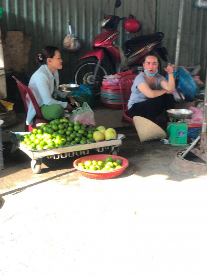 Tiểu thương không đeo khẩu trang hoặc đeo không đúng cách tranh thủ "tám chuyện" khi vắng khách.