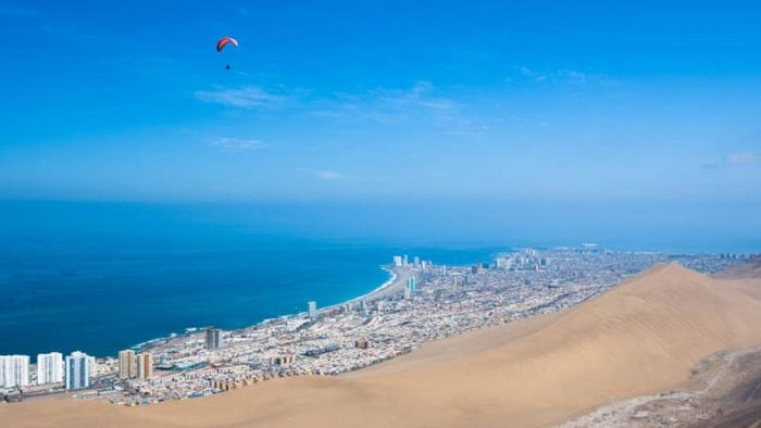 Iquique, Chile. Iquique là thành phố ven biển nằm ở phía Bắc Chile và phía Tây sa mạc Atacama. Nó chỉ nhận được lượng mưa hàng năm chỉ 5mm, thường mưa vào tháng Một hoặc tháng Hai. Mặc dù là một trong những nơi khô hạn nhất trên thế giới nhưng Iquique thu hút rất nhiều du khách đến nghỉ dưỡng. Thành phố này có một số bãi biển giúp xua bớt sự khô hạn cũng như một loạt các khu nghỉ mát tuyệt vời. Du khách cũng bị hấp dẫn bởi trò chơi lướt sóng, mua sắm miễn thuế và sòng bạc bên bờ biển.