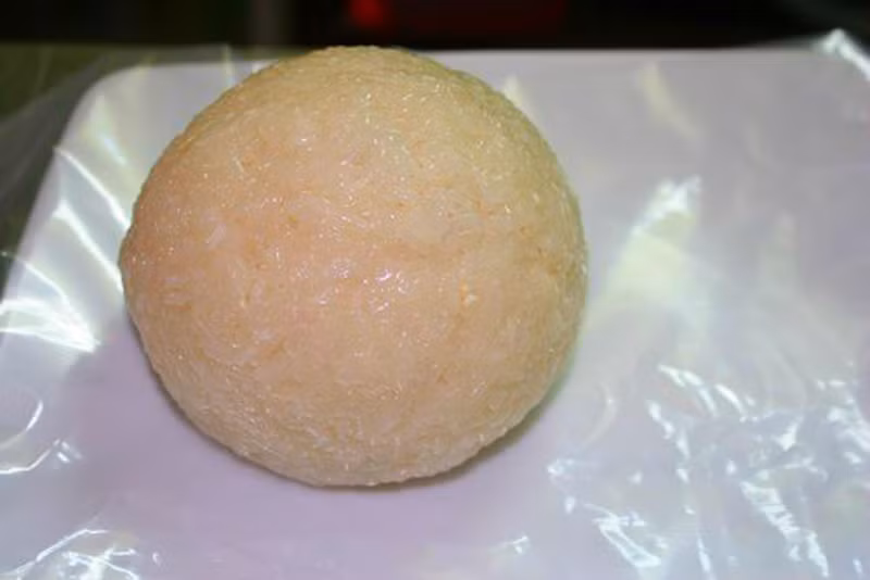 Dùng xôi lá dứa bọc bên ngoài sao cho lớp xôi không quá dày song vẫn đảm bảo các phần quanh chú gà đều được bịt kín.