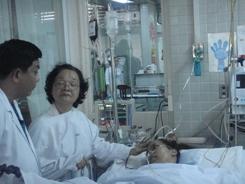 BS.CK II Lê Văn Tuấn và mẹ bệnh nhân đang thăm Nguyễn Thị Hương Thảo tại khoa Hồi sức cấp cứu, BV Chợ Rẫy.