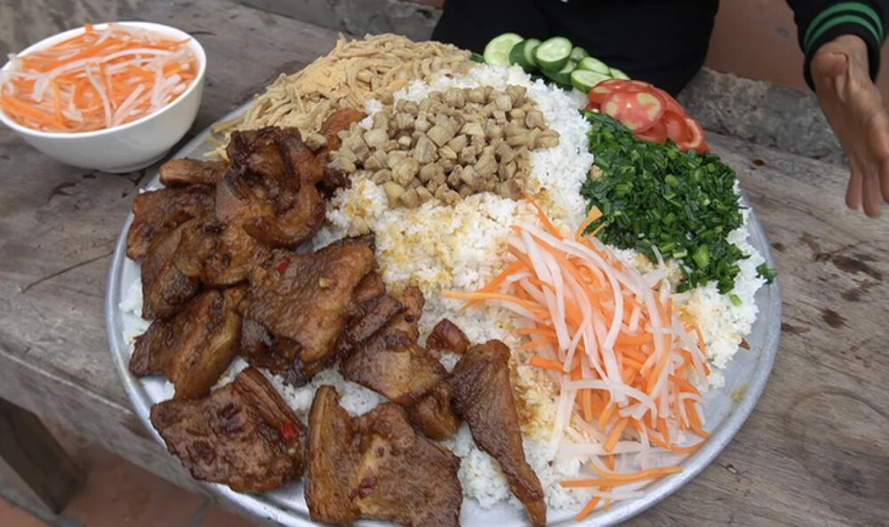 Trong video mới nhất, bà lại khiến nhiều người chú ý khi thực hiện món cơm tấm. Đây được xem là món ăn quen thuộc của người Sài Gòn. Sự hòa hợp của lớp cơm tấm tơi xốp, phần nước mắm chua ngọt đậm đà, sườn nướng thơm lừng và bì chả bùi béo đã tạo nên hương vị đặc trưng cho món ăn. 