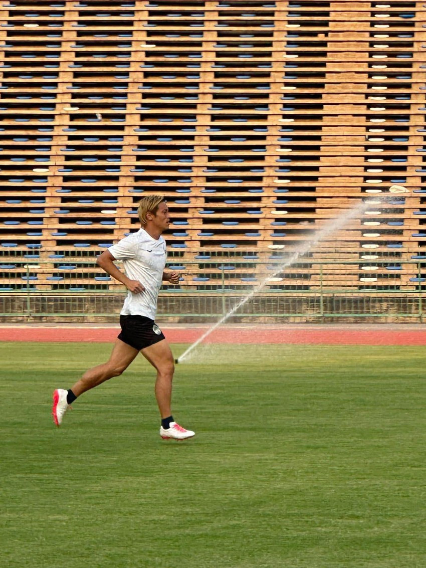 ...Cho đến trước thềm SEA Games 32 này mặt cỏ chỉ được phủ lên để tổ chức các trận bóng đá nam và nữ SEA Games 32. HLV Honda của U-22 Campuchia...thử độ mềm của sân. Ảnh: CTP