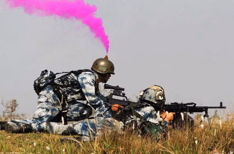 Binh lính Trung Quốc đội mũ cực lạ trong cuộc tập trận bắn đạn thật. Không hiểu vì sao chiếc mũ lại phun khói màu, mục đích để làm gì?