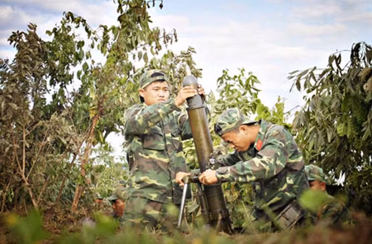 Pháo thủ khẩu đội súng cối 100mm nạp đạn vào nòng chuẩn bị khai hỏa trong khuôn khổ diễn tập khu vực phòng thủ An Giang.