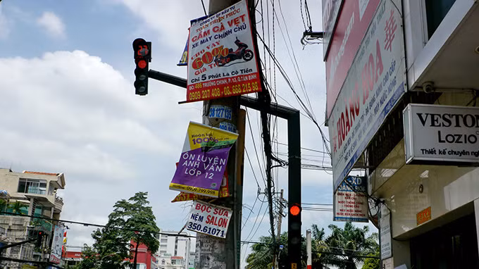 Quảng cáo treo cao hơn đèn tín hiệu giao thông ở góc đường Hồ Văn Huê – Hoàng Văn Thụ, P.9, Q.Phú Nhuận.
