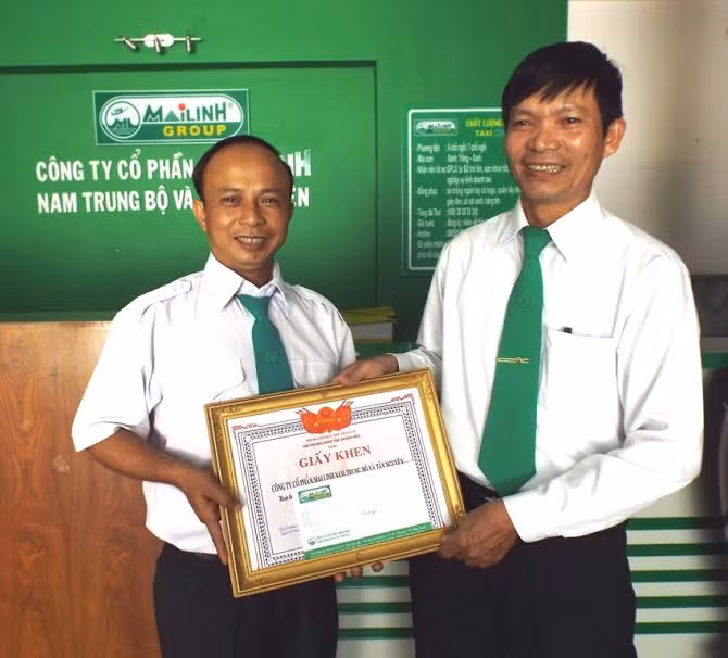 Ông Vũ Xuân Tứ, Chủ tịch công đoàn Mai Linh trao giấy khen và tiền thưởng cho lái xe Nguyễn Phú Công.