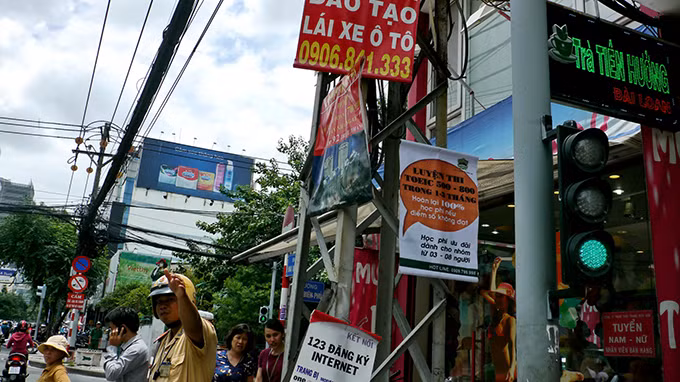 Cột điện ngay vị trí CSGT điều hành giao thông ở ngã tư Điện Biên Phủ - Hai Bà Trưng, P.6, Q.3 cũng đầy quảng cáo.