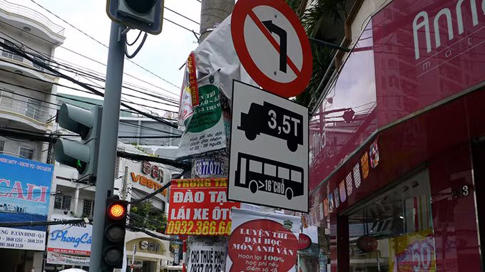 Quảng cáo treo đầy cột điện, treo sang cột biển báo giao thông ở góc đường Lý Chính Thắng – Hai Bà Trưng, P.8, Q.3.