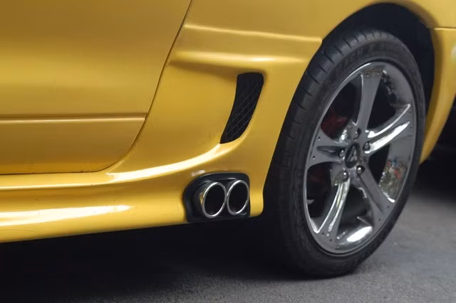 Cặp ống xả sáng bóng đặt gần bánh sau cùng bộ vành 5 chấu đơn thể thao.