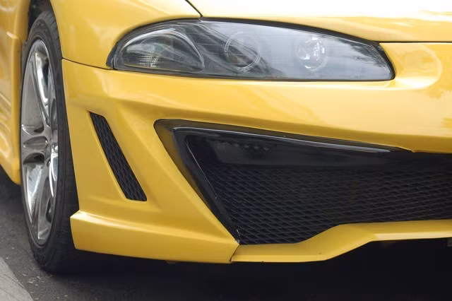 Ở bộ kit mới, Eclipse Coupe trở nên thể thao gân guốc khi cản trước được mở rộng tăng vẻ lạ lẫm và cuốn hút hơn với người đối diện. Những đường nét khỏe khoắn được tái hiện rõ nét với những gờ nổi bên hông xe.