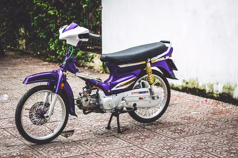 Sau khi độ lại, chiếc Dream trở nên cuốn hút hơn nhiều với màu áo tím mộng mơ cùng vô số đồ chơi sành điệu. Đầu xe được chủ nhân độ lại bằng đầu của Honda Click.