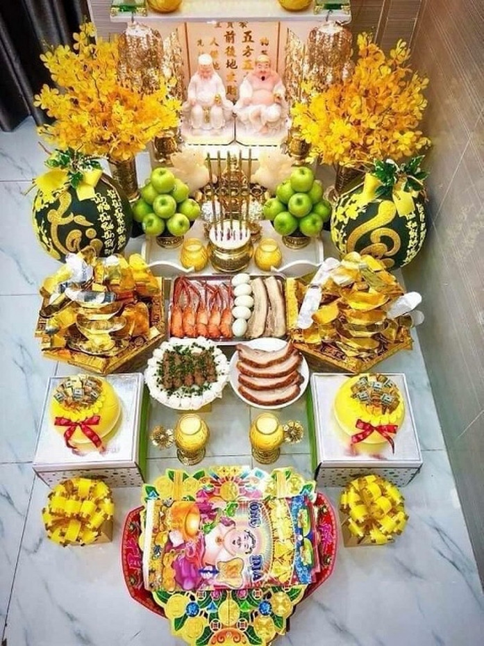 Theo truyền thống, mâm cúng vía Thần Tài gồm có các lễ vật: nến, hương, nước (3 chén), rượu (3 chén), gạo tẻ (1 đĩa), muối (1 đĩa), tiền vàng mã, hoa tươi, mâm ngũ quả, trầu cau, mâm cỗ mặn (tùy từng gia đình). (Ảnh minh họa: Internet).