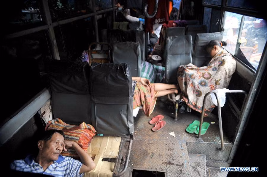 Người dân nghỉ ngơi trong một chiếc xe buýt được trưng dụng làm nơi trú ẩn tạm thời,
