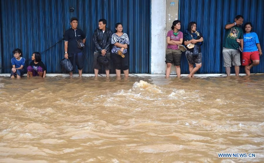 Mọi người đứng ở trước một cửa hiệu với hi vọng nước sẽ rút xuống để trở về nhà.