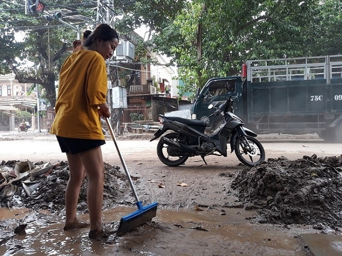 “Lớp bùn non quá dày khiến cho việc dọn dẹp nhà cửa mất rất nhiều thời gian và công sức, dọn mãi vẫn không thấy sạch. Nước lũ rút tới đâu chúng tôi tranh thủ dọn dẹp tới đó", chị Ly nói. (Chị Ly (ở thị xã Quảng Trị) đang tích cực quét, dọn bùn ra khỏi nhà)