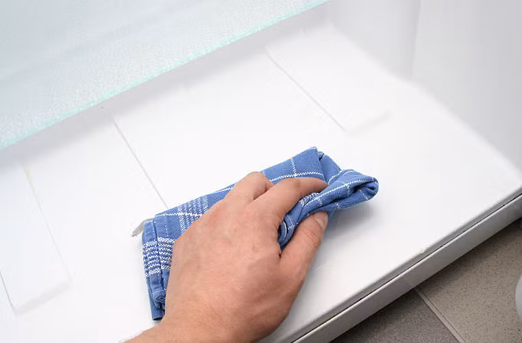 Dùng một chiếc khăn khô tiến hành lau lại toàn bộ bề mặt tủ lạnh.