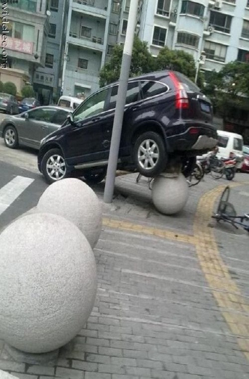 Chiếc xe mất lái, lao lên vỉa hè. Tuy nhiên để thăng bằng trên những quả bóng bê tông như thế này hẳn chỉ có tài xế mới biết được là vì sao.