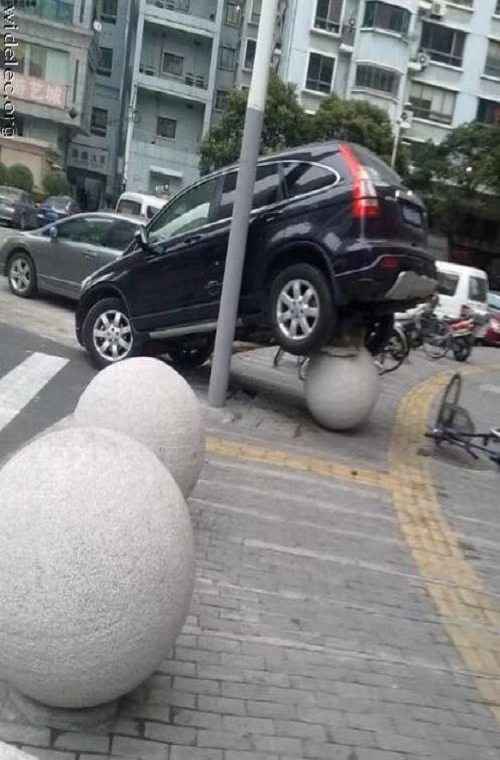 Chiếc xe mất lái, lao lên vỉa hè. Tuy nhiên để thăng bằng trên những quả bóng bê tông như thế này hẳn chỉ có tài xế mới biết được là vì sao.