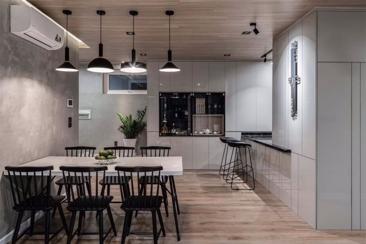 ##sc### Khu vực bếp và phòng ăn nằm ở phía sâu, thiếu ánh sáng tự nhiên nên được ưu tiên nhiều màu trắng hơn ở hệ tủ bếp. Chất liệu gỗ ở trần và sàn màu nâu và tường màu xám vẫn là màu chủ đạo 