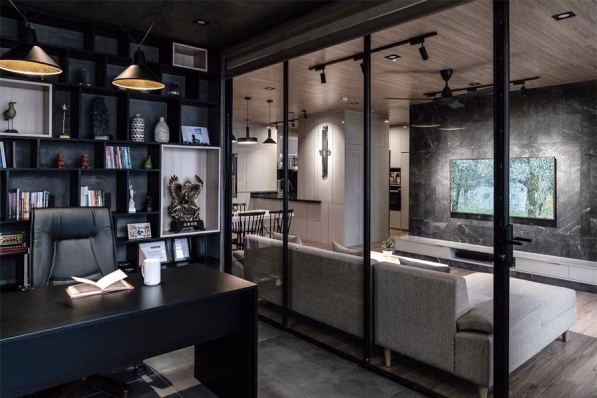 ##sc### Khu bếp nấu được ngăn cách riêng, và kết nối với bàn ăn thông qua một quầy bar. Phần tường bếp giữa tủ dưới và tủ trên ốp kính màu đen, cùng mặt đá đen tương phản mạnh mẽ với sắc trắng của hệ thống tủ bếp. 