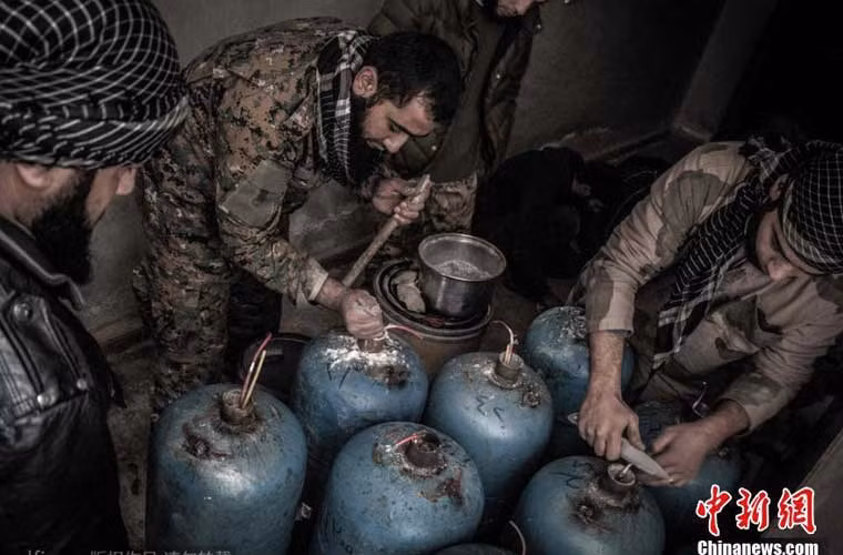 Một trong những vũ khí tự chế đáng sợ nhất của quân nổi dậy Syria là…bom bình gas – đó là những bình gas được nhồi hàng kg thuốc nổ và được bắn bằng bệ phóng tự chế vào khu vực quân chính phủ ẩn núp. Độ chính xác có thể thể kém nhưng sức công phá của nó là không thể không để tâm. Trong ảnh, nhóm quân nổi dậy đang nhồi thuốc nổ và làm dây dẫn nổ cho quả bom bình gas.