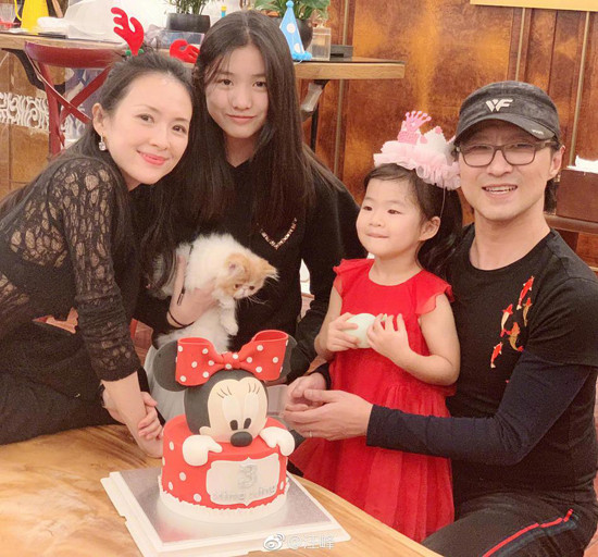 Trong ảnh, “nhân vật chính” mặc váy đỏ xinh xắn, còn các thành viên còn lại mặc đồ đen, tất cả đều mỉm cười rạng rỡ.