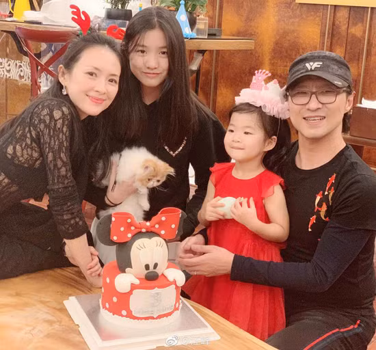 Trong ảnh, “nhân vật chính” mặc váy đỏ xinh xắn, còn các thành viên còn lại mặc đồ đen, tất cả đều mỉm cười rạng rỡ.